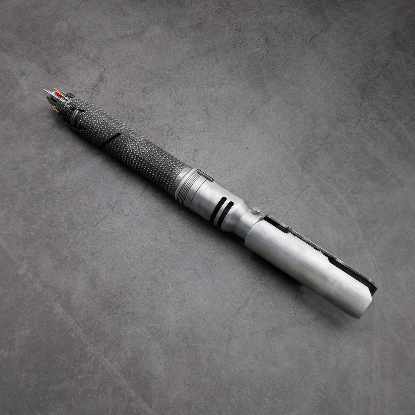 Star Wars Luke Skywalker lightsaber hilt with textured grip and metallic finish on gray surface